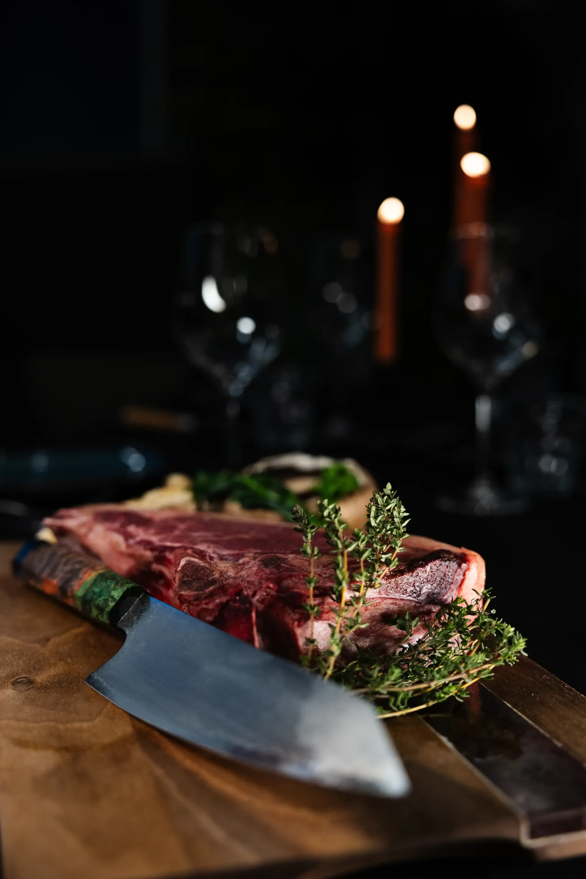 Vlees aangesneden bij kaarslicht op een houten plank in restaurant VUUR.