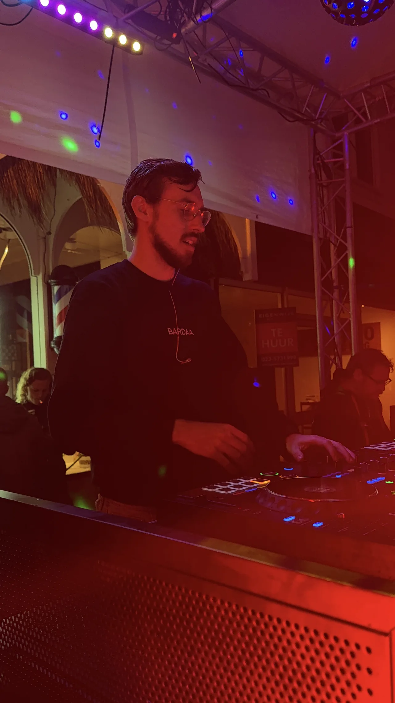 BARDAA achter de decks in rood en paars podiumlicht.